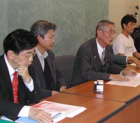（厚生労働大臣への要請後、記者会見で日本の癌治療の改善を訴える新山会長〈右から２人目〉と仙谷由人議員〈左端〉）
